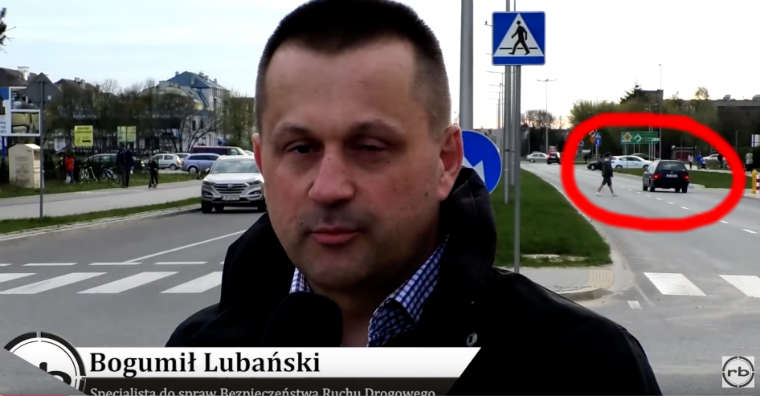 Kadr spotu z kampanii "Świeć życiem" z Białej Podlaskiej, w którym za wypowiadającym się ekspertem widać pieszego przechodzącego przez drogę poza przejściem dla pieszych. Źródło: YouTube