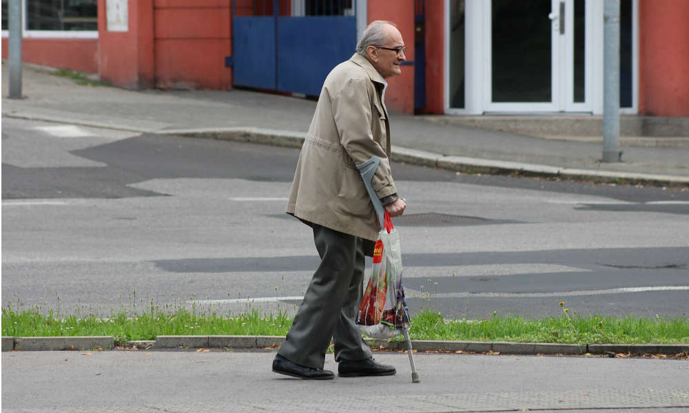 Starszy pieszy idący o kulach Fot. CC0
