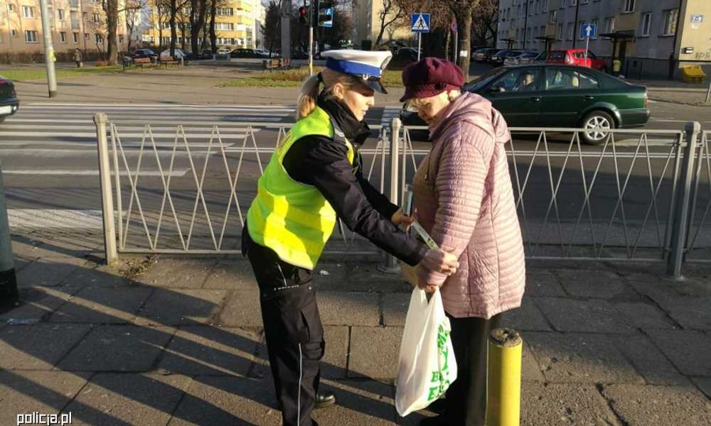 Policjantka wręczająca odblask seniorce podczas policyjnej akcji "Babciu, Dziadku, coś Ci damy - kolorowy odblask, który mamy" Fot. Policja